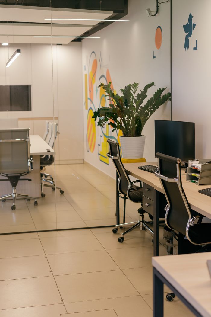 project-01-b A roomy, modern office interior with glass partitions, elegant furniture, and colorful wall art.